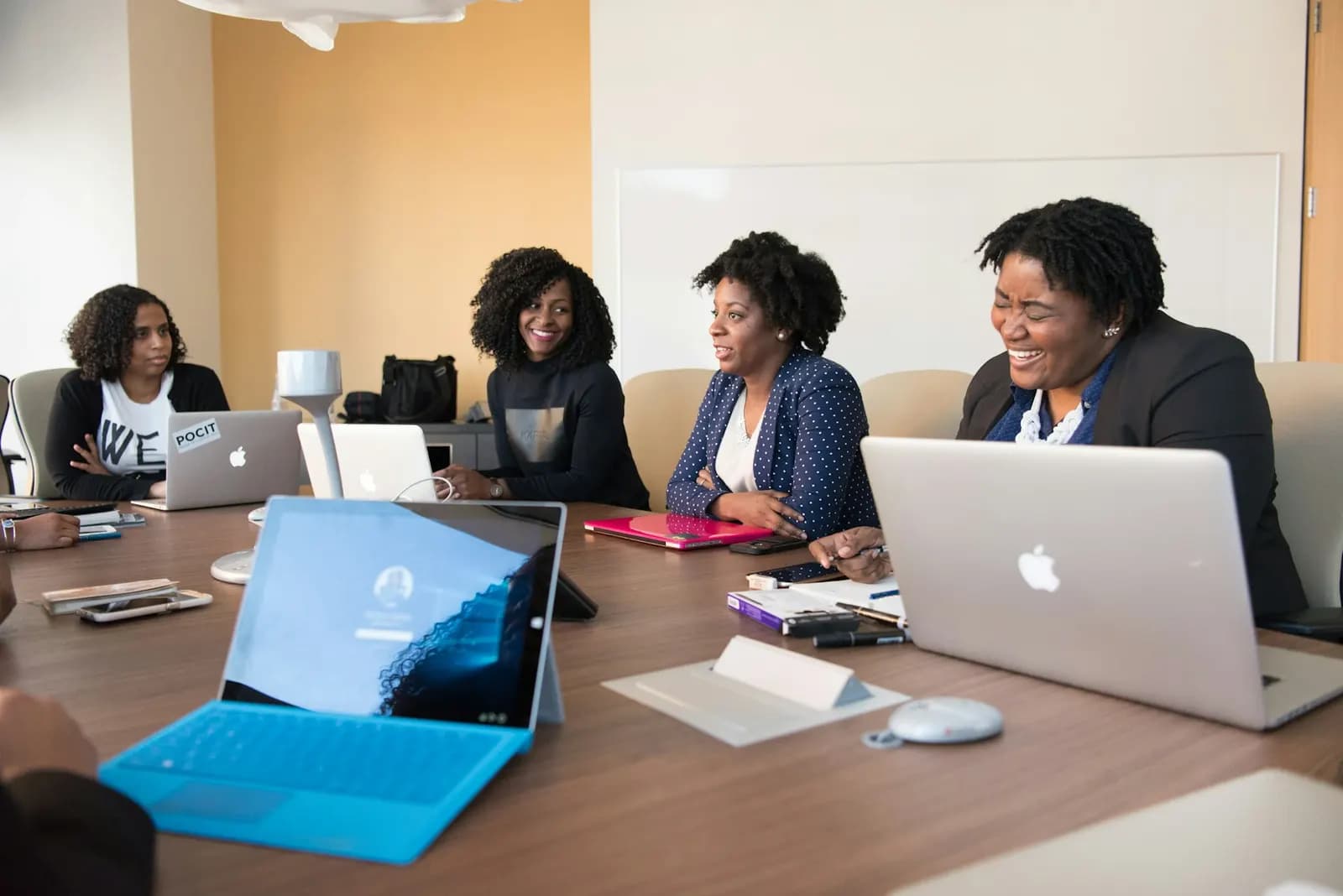 Team collaborating with laptops around a meeting table